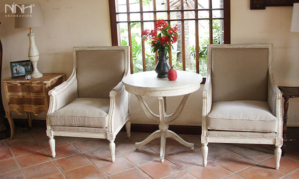 Two white arm chairs and round table